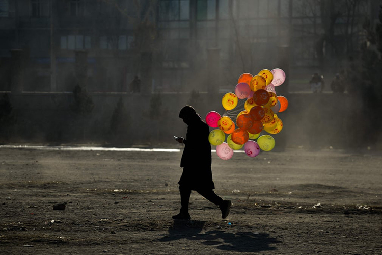 بادکنک فروش افغان در حال عبور از منطقه چمن حضوری. کابل، افغانستان