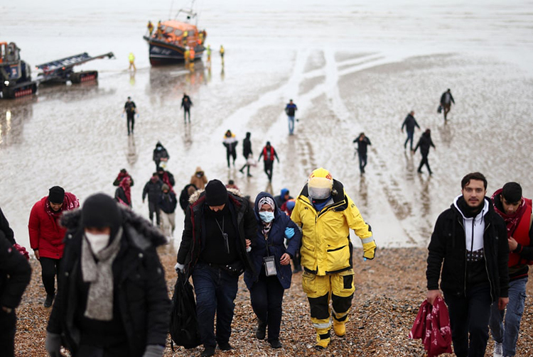 مهاجران پس از نجات در حین عبور از کانال توسط یک قایق نجات RNLI در Dungeness به ساحل منتقل میشوند. دانجنس، انگلستان مهاجران پس از نجات در حین عبور از کانال توسط یک قایق نجات RNLI در Dungeness به ساحل منتقل میشوند. دانجنس، انگلستان