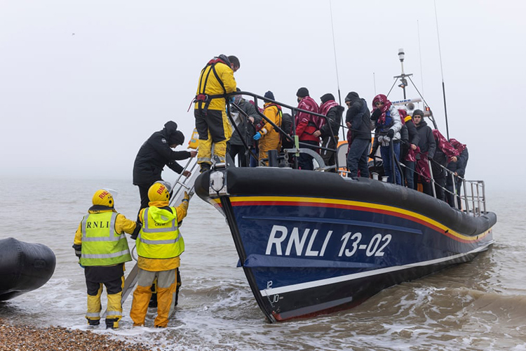 اعضای RNLI و نیروی های مرزی پس از عبور از کانال مه آلود به پناهندگان کمک می کنند تا به ساحل برسند. دانجنس، انگلستان