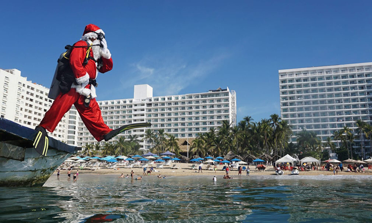 غواصی با لباس بابانوئل در ساحل آکاپولکو به دریا می پرد.گوئررو، مکزیک