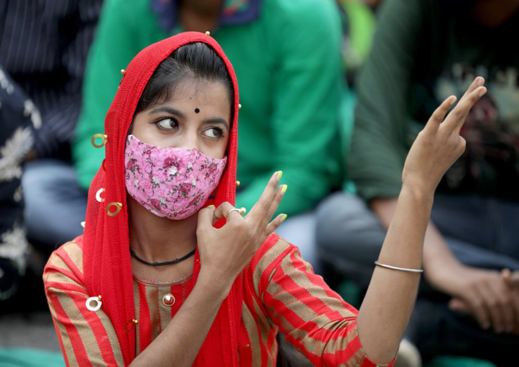 یک زن در روز جهانی افراد دارای معلولیت با زبان اشاره ارتباط برقرار می کند. کلکته، هند