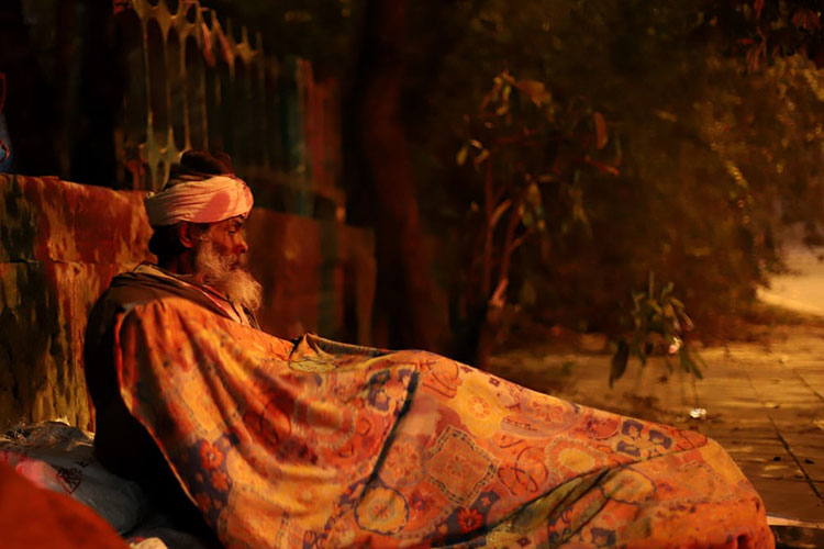 مردی بی خانمان در یک غروب سرد زمستانی برای یک شب خواب در فضای باز آماده می شود.<br />دهلی نو، هند