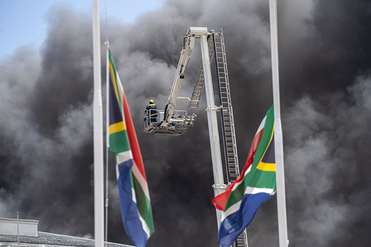 آتش نشانان در حال خاموش کردن آتش سوزی ساختمان مجلس کشور آفریقای جنوبی.  کیپ تاون، آفریقای جنوبی