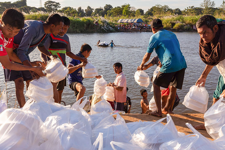 آوارگان میانمار که در یک کمپ موقت در کنار رودخانه موئی زندگی می کنند، کالاهای اهدایی دریافت می کنند. منطقه مای سوت، تایلند