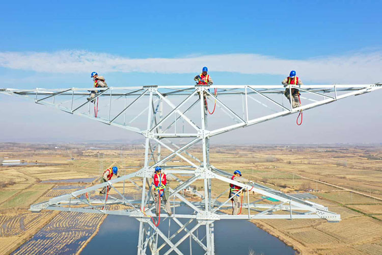 برقکارها روی یک برج انتقال و تبدیل فشار قوی 220 کیلو ولت در شهرستان کوانجیائو کار می کنند. چوژو، چین