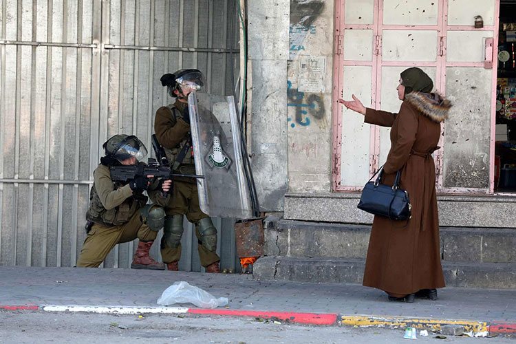 سربازان اسرائیلی پس از اعتراضات در مرکز شهر هبرون، علیه فلسطینی ها گارد می گیرند.<br />هبرون، کرانه غربی