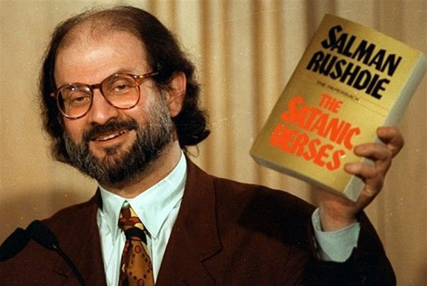سلمان رشدی در حالی که کتاب جنجالی اش را در دست دارد