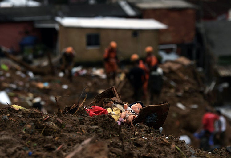 یک عروسک در میان آوار قرار دارد در حالی که پرسنل نجات آتش نشانی به دنبال بازماندگان پس رانش زمین می گردند.<br />پتروپولیس، برزیل