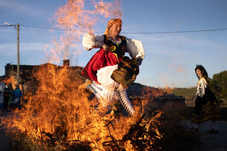 یک زن اسپانیایی با لباس محلی در مراسم یادبود  Santa Agueda از روی آتش می پرد.<br />زامورا، اسپانیا