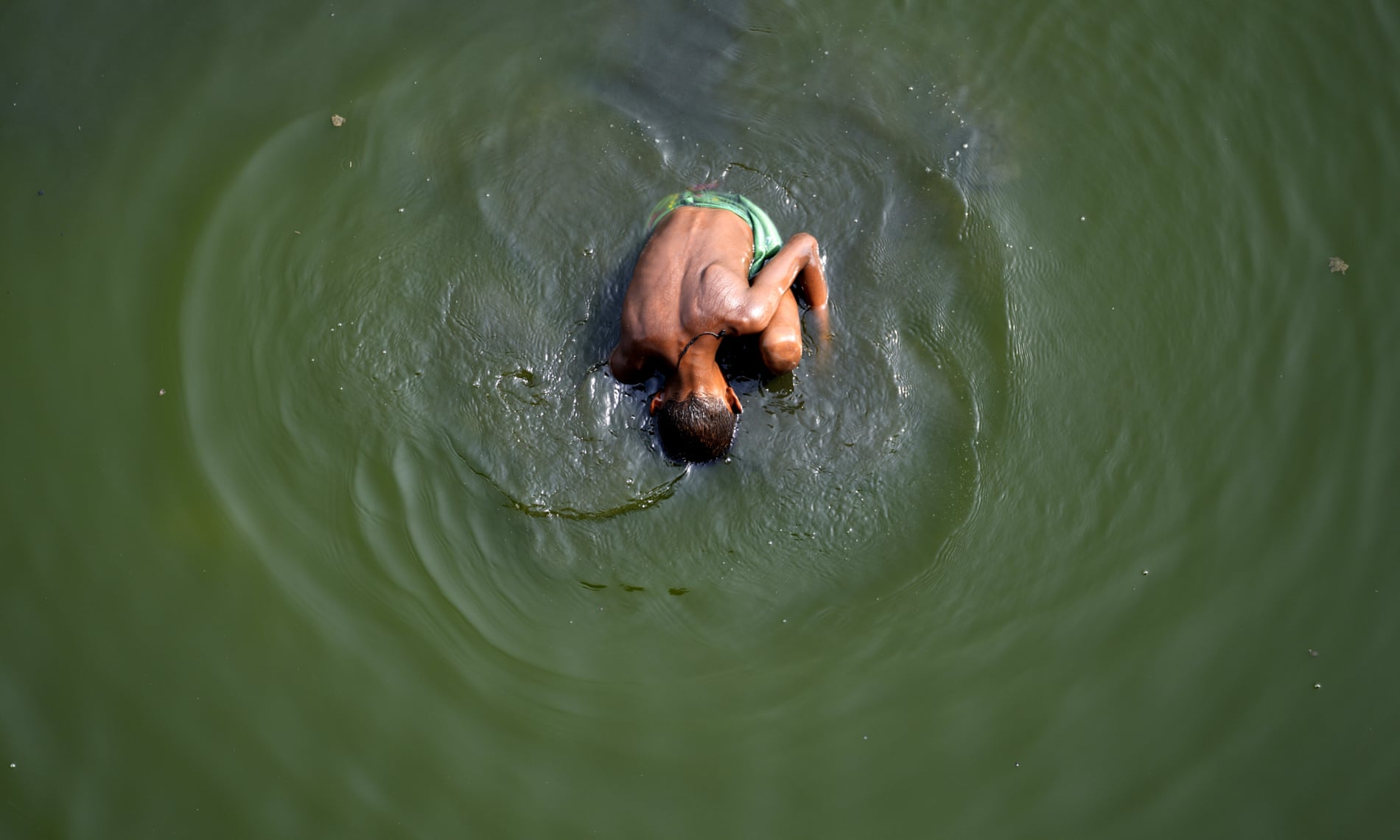 دهلی، هند پسری در جستجوی چندین سکه در آب