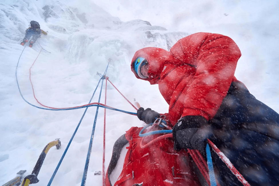  یک کوهنورد در حال آمادگی برای بالا رفتن از دیوار یخی 