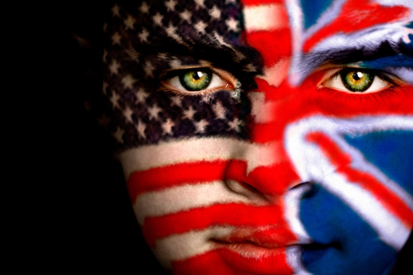 Portrait of a young boy with one half of his face painted with the Union Jack of Great Britain and the other half with the Flag of the USA.