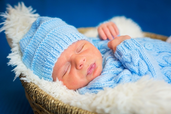 Newborn baby boy portrait in blue knitted hat
