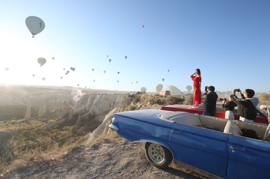 گردشگران در حال عکس و فیلم گرفتن از بالن‌ها در شهر گردشگری کاپادوکیه ترکیه