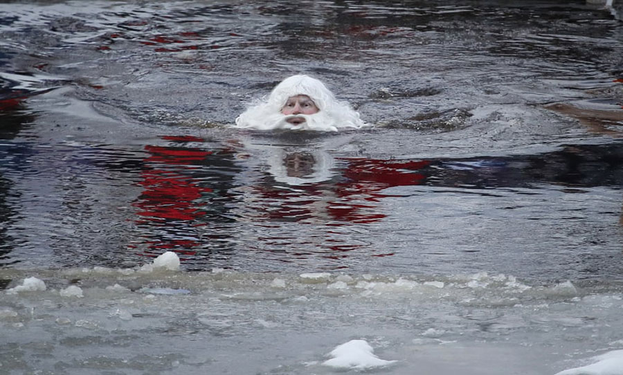 شنای بابانوئل روسی در یک رودخانه یخ زده در اولونِتس روسیه