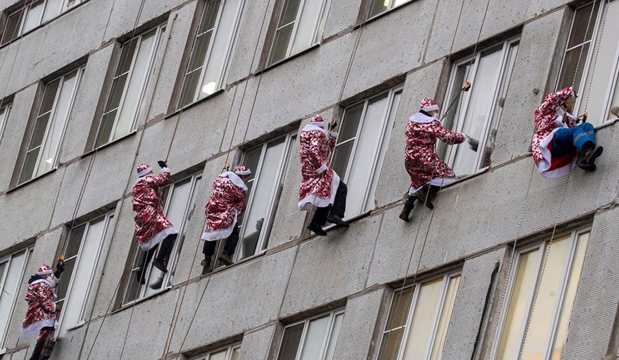 آتش نشانان و امدادگران روسی با لباس های بابانوئل در یک برنامه خیریه درحال پایین آمدن از دیوار یک بیمارستان