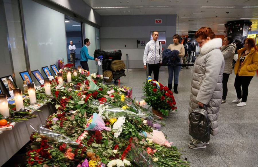 حاضران در فرودگاه بین المللی کی‌یف به یادبود خلبانان و پرسنل هواپیمای اوکراینی سقوط کرده در ایران می‌نگرند