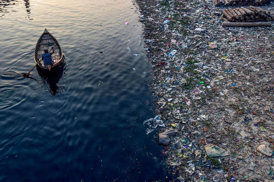 قایقرانی در یک رودخانه آلوده در بنگلادش