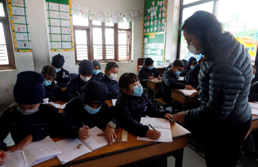پوشش ماسک صورت به دلیل شیوع جهانی ویروس کرونا، توسط یک معلم و شاگردانش در مدرسه‌ای در باکتاپور، نپال