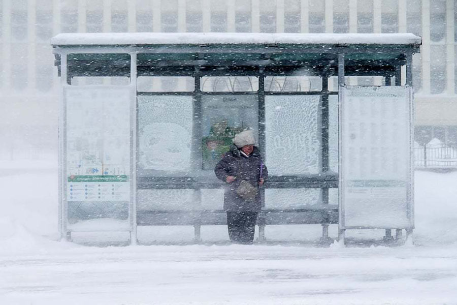 یک زن هنگام وقوع طوفان در ایستگاه اتوبوس در روسیه