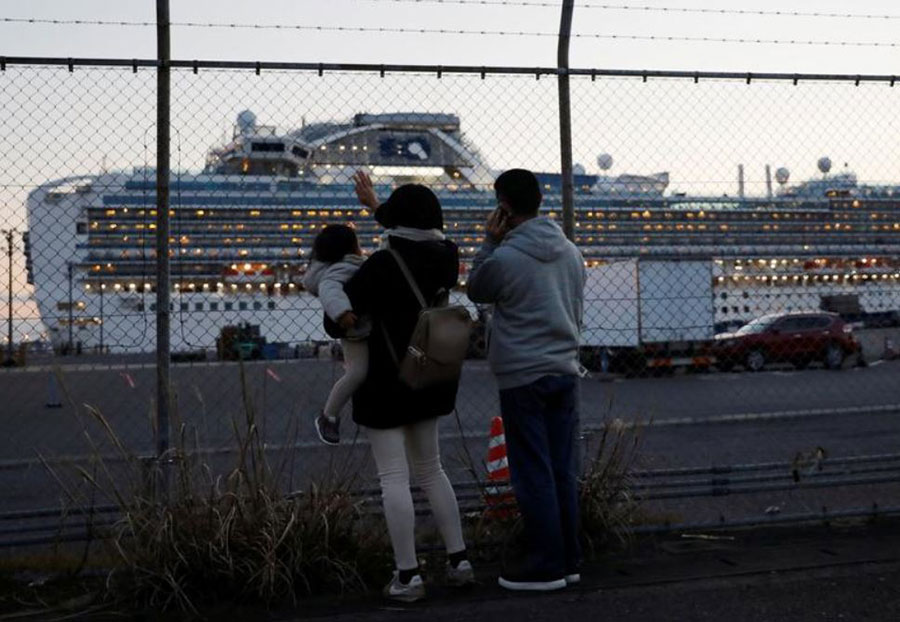 خانواده مسافران کشتی تفریحی در قرنطینه دایموند پرنسس در حال دست تکان دادن به اعضای خانواده‌شان در ترمینال بندریوکوهاما ژاپن