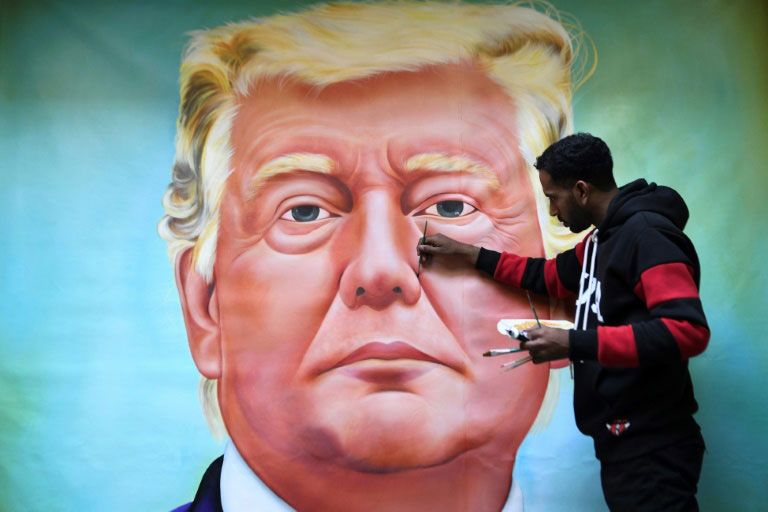 نقاش هندی در حال کشیدن تصویر رییس جمهوری آمریکا روی دیوار در شهر آمریتسار در آستانه سفر رسمی دونالد ترامپ به هندوستان