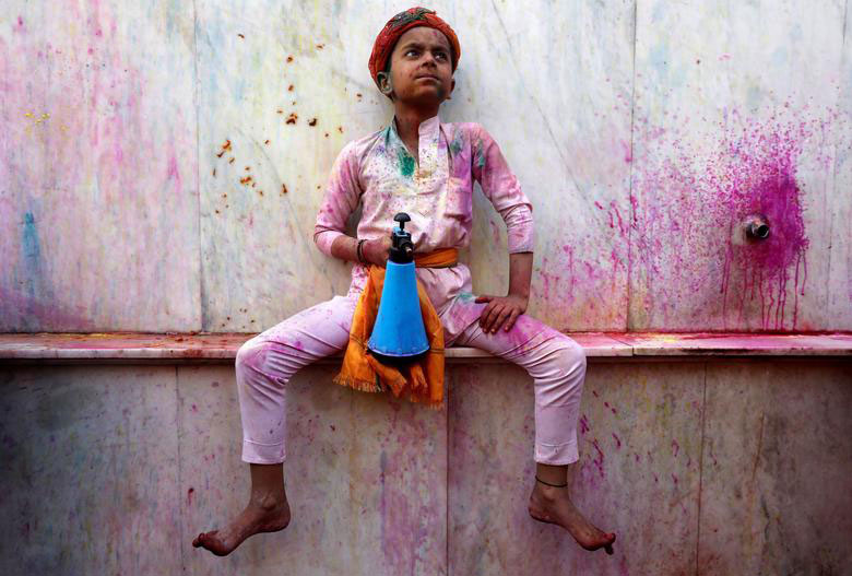 کودک هندو در جریان یک جشنواره آیینی هندوها در معبدی در اوتارپرادش هند، اسپری ضدعفونی به دست گرفته است