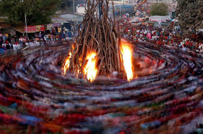 روشن کردن آتش در جریان یک جشنواره آیینی هندوها در شهر احمدآباد هند