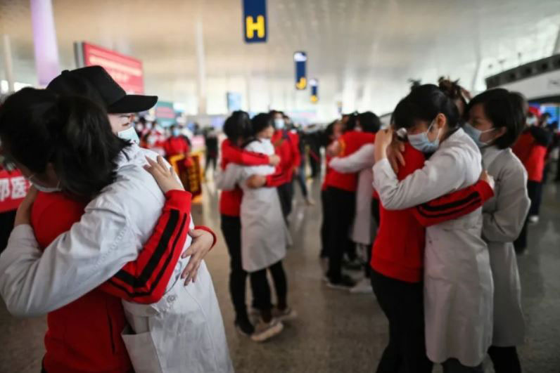 کادر درمانی مهمان از شهر جیلین چین که طی 3 ماه گذشته برای درمان بیماران کرونایی به شهر ووهان آمده بودند در حال خداحافظی از همکاران ووهانی خود پیش از عزیمت به شهرشان در فرودگاه بین‌المللی شهر ووهان