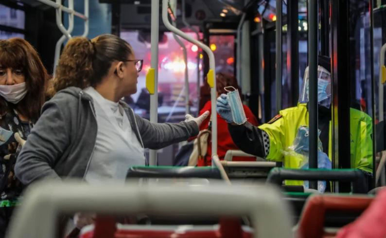 اعطای ماسک از سوی پلیس اسپانیا به یک مسافر اتوبوس در نخستین روز کاری پس از تعطیلات عید پاک و قرنطینه سراسری