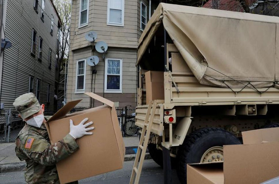 نیروی گارد ملی آمریکا در حال تخلیه کامیون حامل مواد غذایی برای توزیع در یک مرکز در شهر چلسی ایالت ماساچوست آمریکا