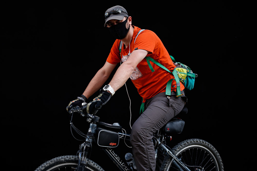 ماسک هایی برای کرونا؛ یک دوچرخه سوار به جهت تمرین روزانه و رکاب زدن در خیابان حضور دار
