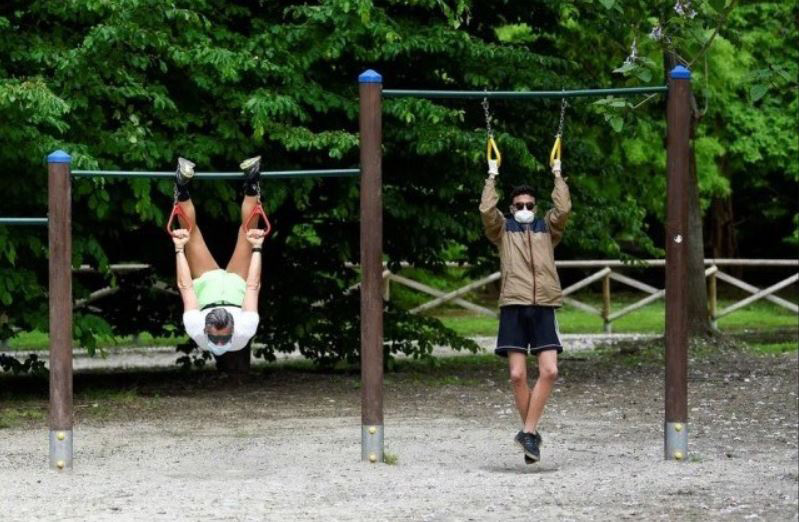با کاهش محدودیت‌های قرنطینه سراسری در ایتالیا شهروندان در پارکی در شهر میلان در حال تمرینات ورزشی هستند