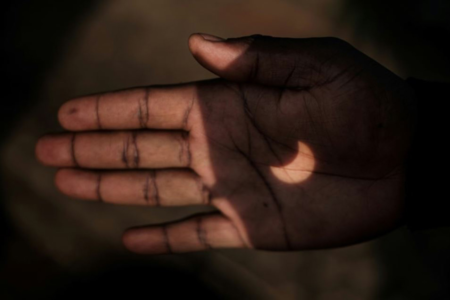 بازتاب خورشیدگرفتگی روی دست مرد کنیایی نایروبی