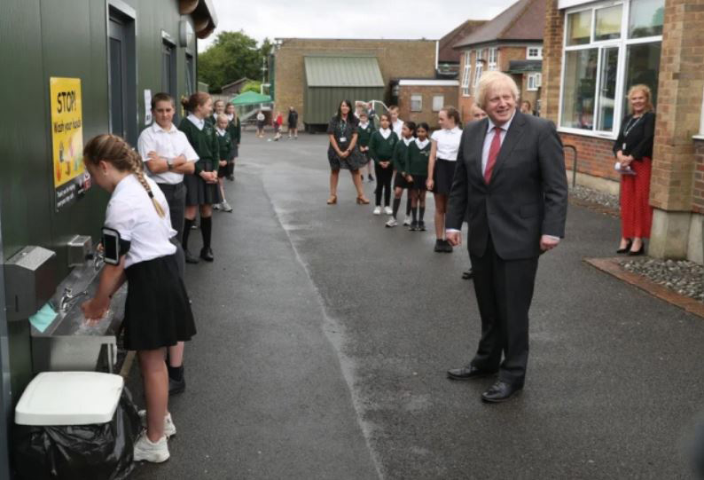 ایستادن نخست وزیر بریتانیا در صف شستن دست در جریان بازدید از مدرسه‌ای در بریتانیا