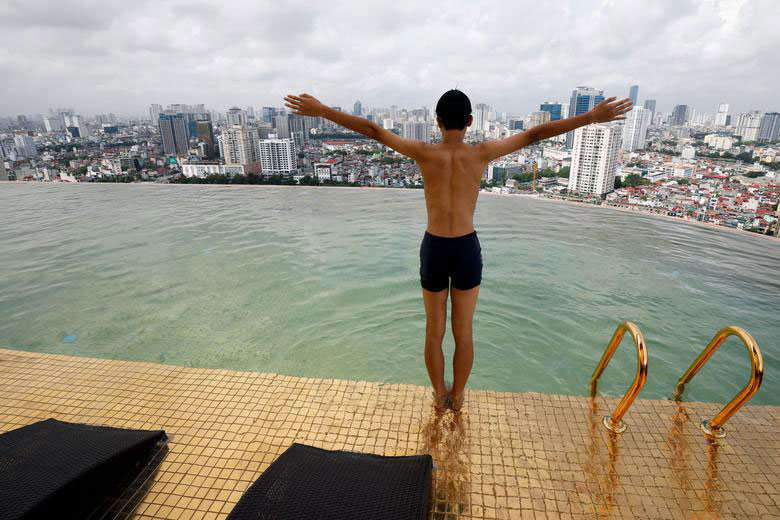 شنای یک مسافر در استخر نخستین هتل با روکش طلا در جهان در شهر هانوی ویتنام