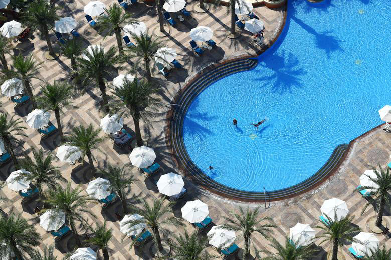 مسافران اندک در حال شنا در استخر هتل آتلانتیس د پالم در شهر دوبی
